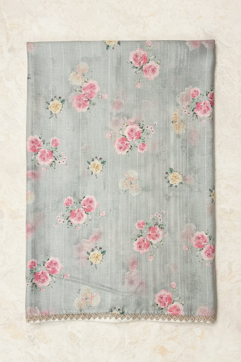 A light blue organza fabric with a pink and yellow floral print, featuring a decorative gold embroidered border on one side.